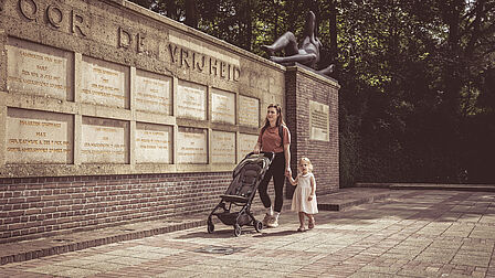Vrouw en kind lopen langs het Mausoleum in Ede