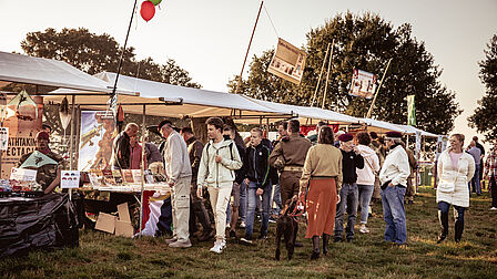 Bezoekers bekijken de kramen op de Airborne Markt