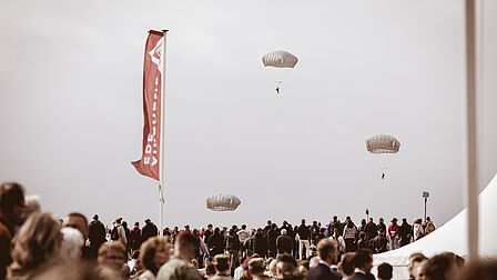 foto van parachutisten die uit vliegtuig springen