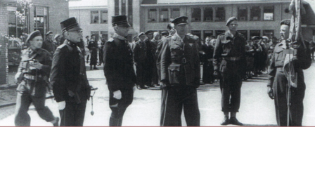 Militairen staan opgeteld bij een vlag. 